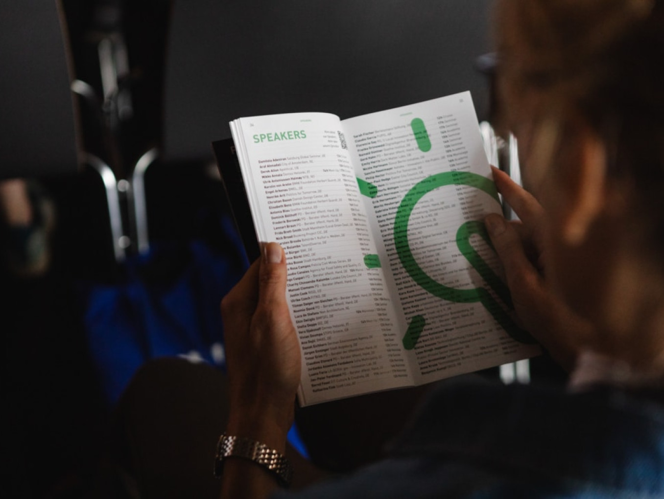 person holding a print programme in their hands