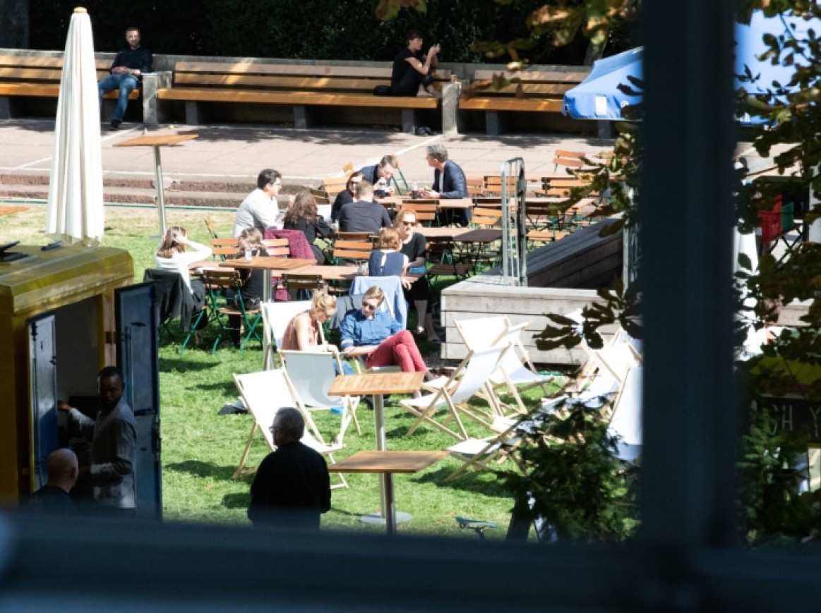 outside area of the festival, chairs on gras and people sitting and talking 